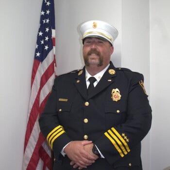 Jordan Peters in uniform next to flag